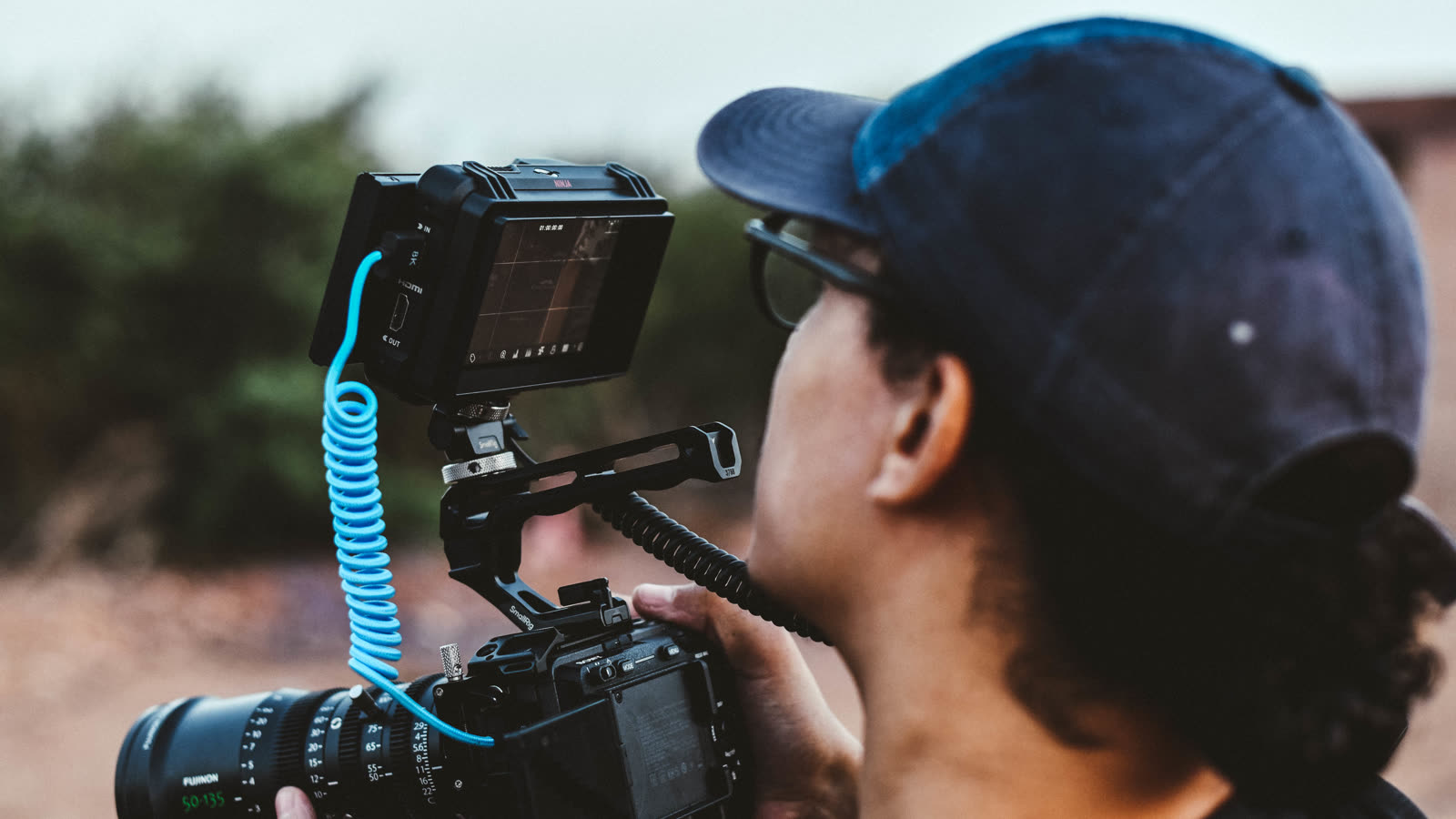 Tournage de film institutionnel au Maroc : cadreur au travail derrière une caméra cinéma équipée d'une optique et d'un moniteur de contrôle