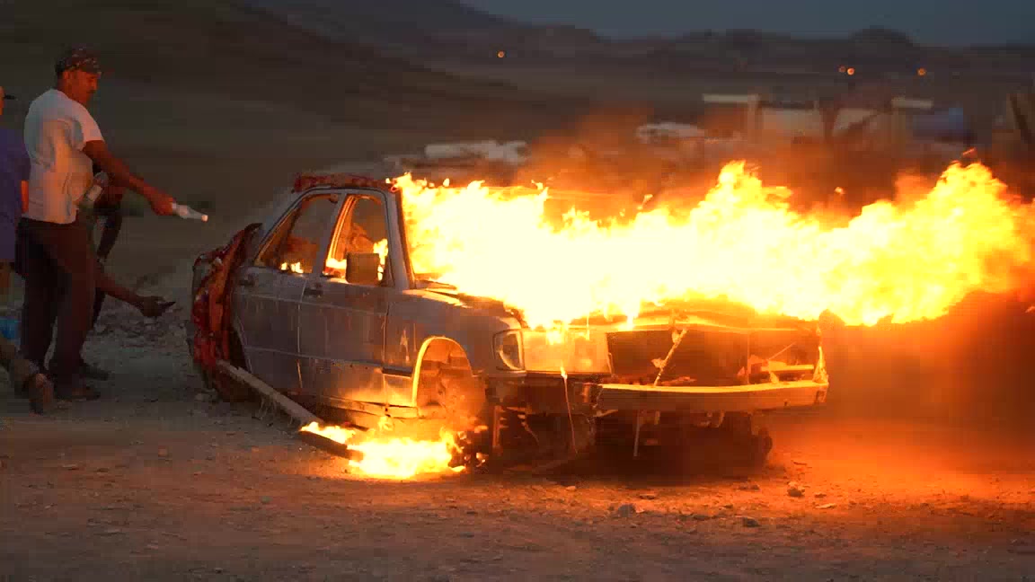 Effets spéciaux sur un tournage au Maroc : véhicule embrasé sous la surveillance d'un technicien pyrotechnie