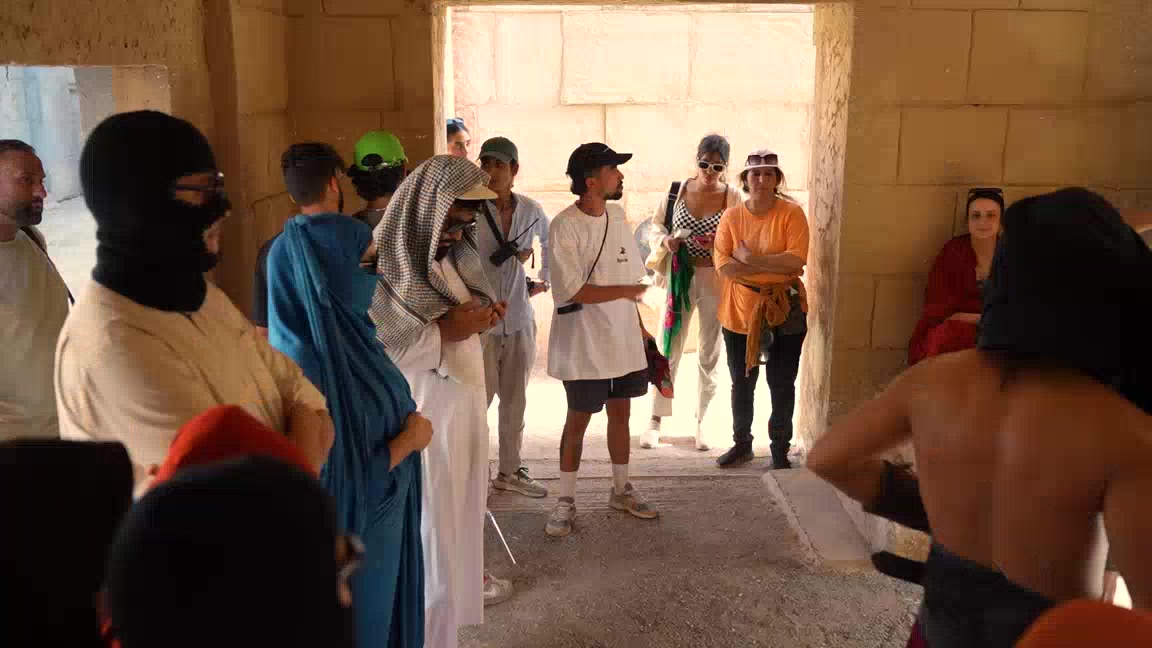 Figurants en costume et équipe technique réunis dans un décor de ksar lors d'un tournage au Maroc