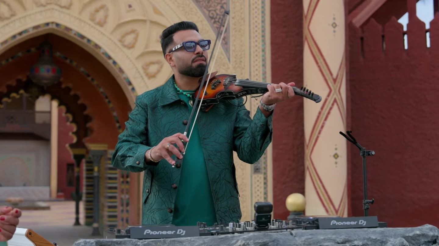 Musiciens jouant en direct sur un tournage de clip à Marrakech : violoniste et platines devant une arche de palais