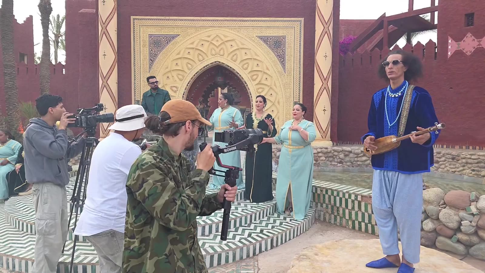 Tournage de clip musical au Maroc : trois cadreurs filment simultanément une scène dans un décor de palais marocain