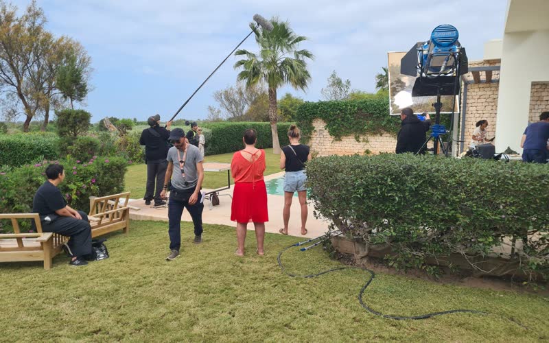 Équipe de tournage publicitaire installée dans le jardin d'une villa au Maroc