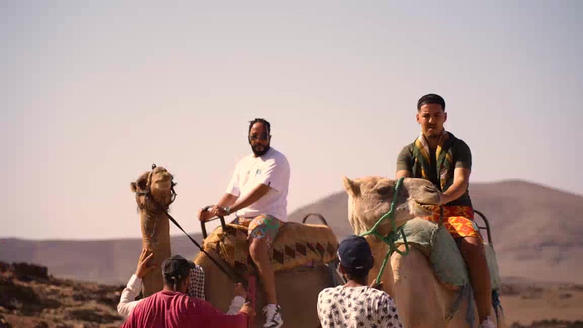 Tournage de clip dans le désert marocain : artistes à dos de chameau avec l'équipe locale
