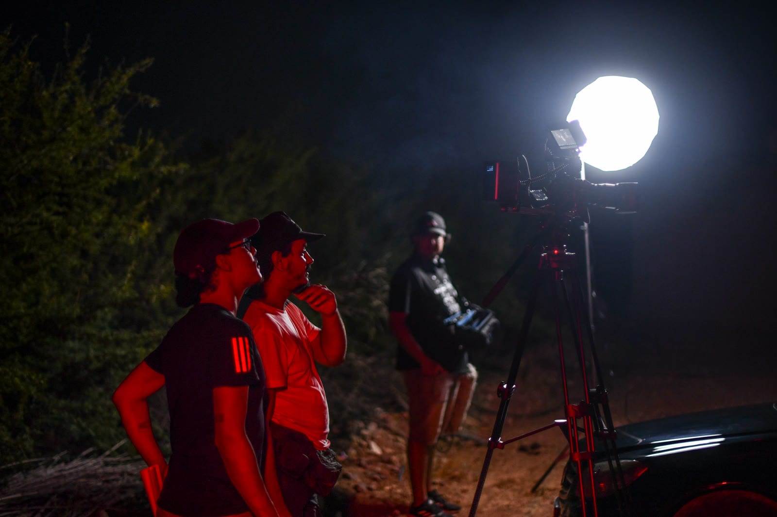 Tournage de nuit au Maroc : équipe autour d'une caméra éclairée par un ballon lumineux